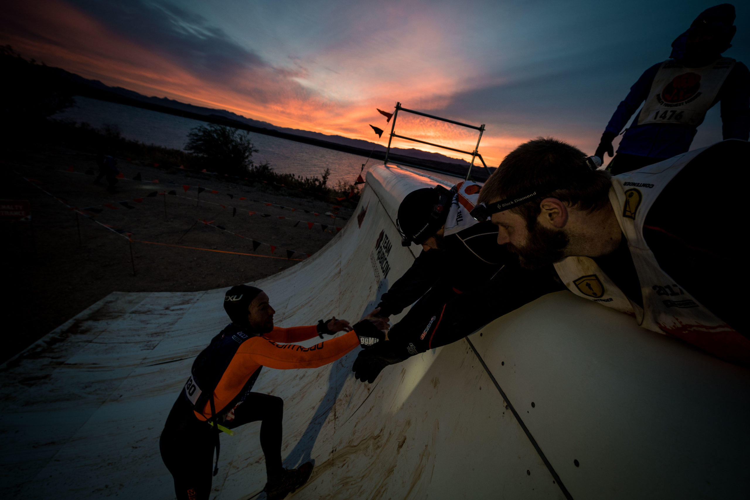 Two men pull a third up a ramp
