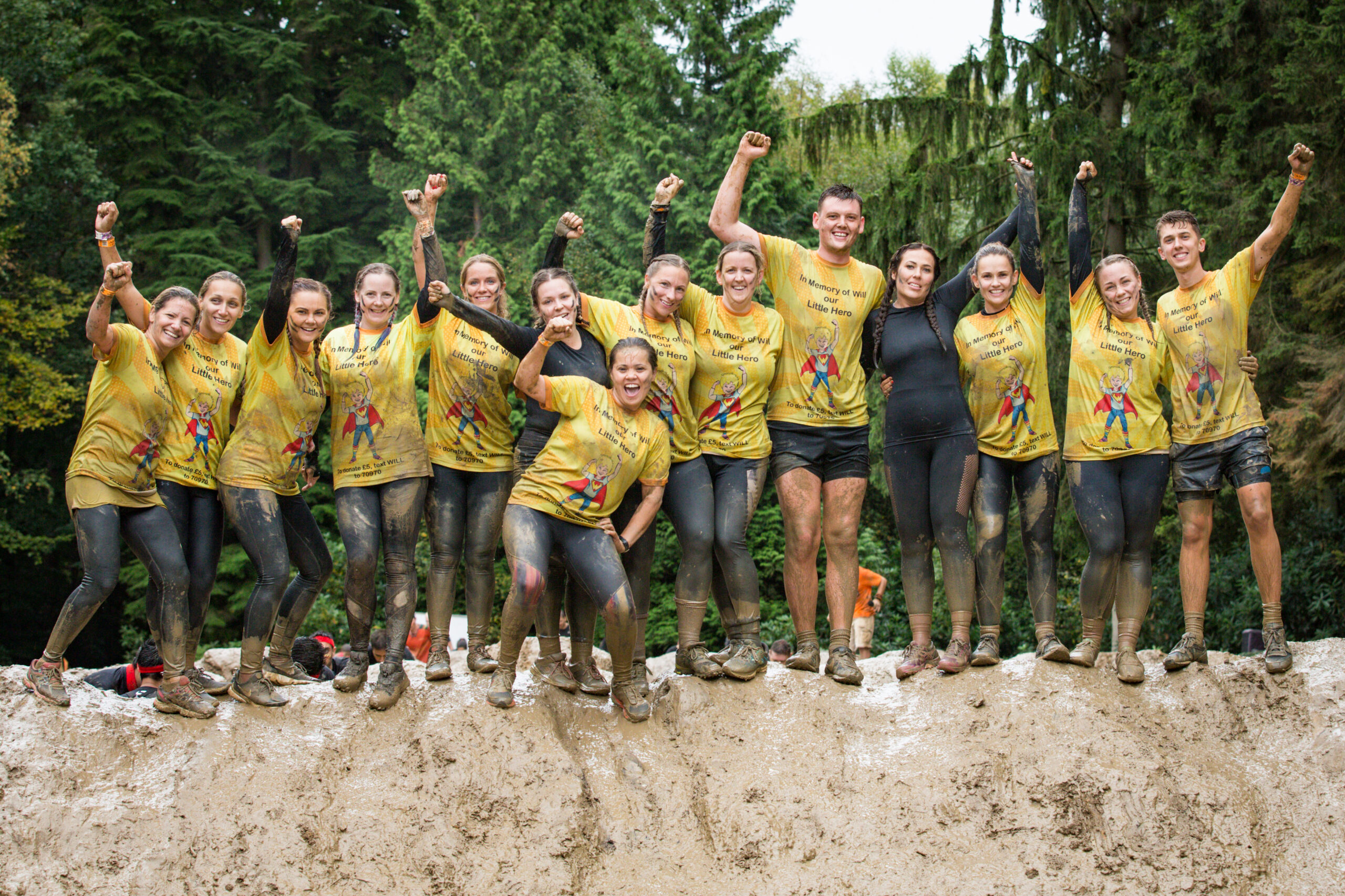 Group participants smiling for a pose with mud in their bodies
