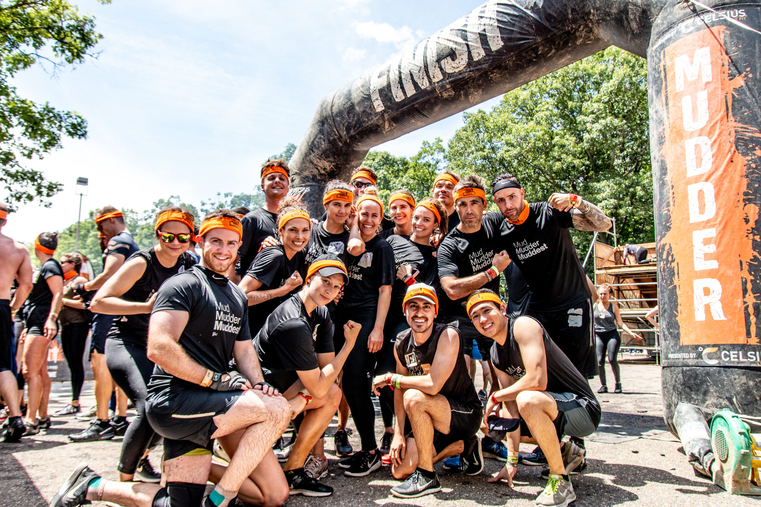 Group participants flexing their muscles in the finish line