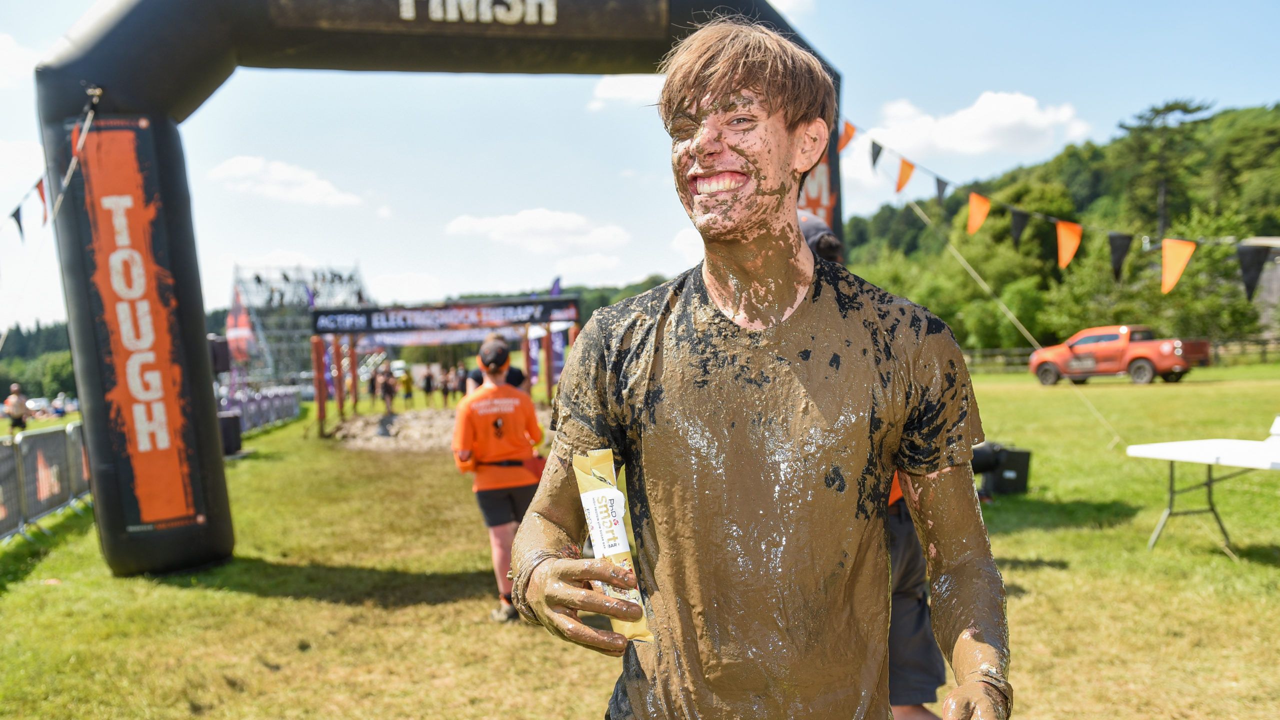 man covered mud smiling