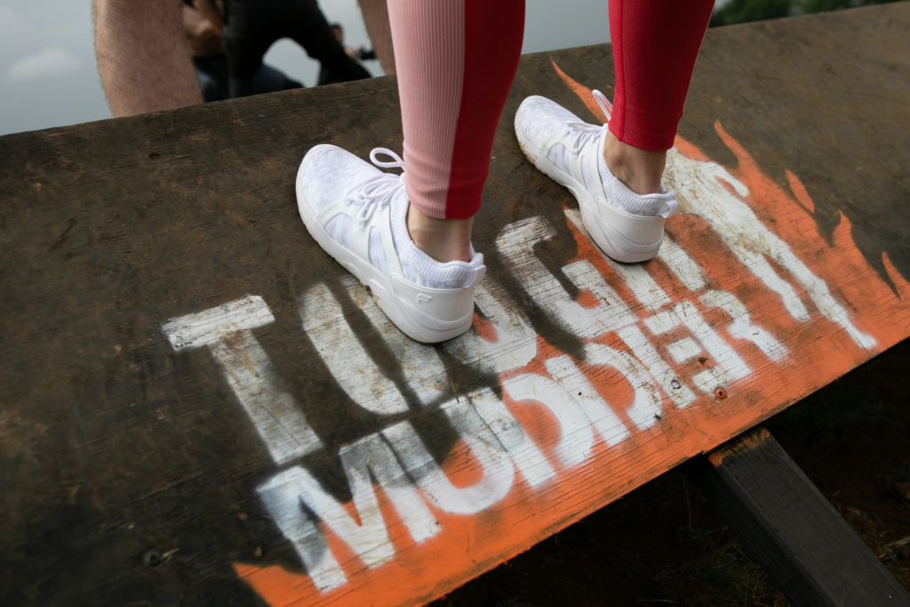 fabletics white trainers on tough mudder obstacle