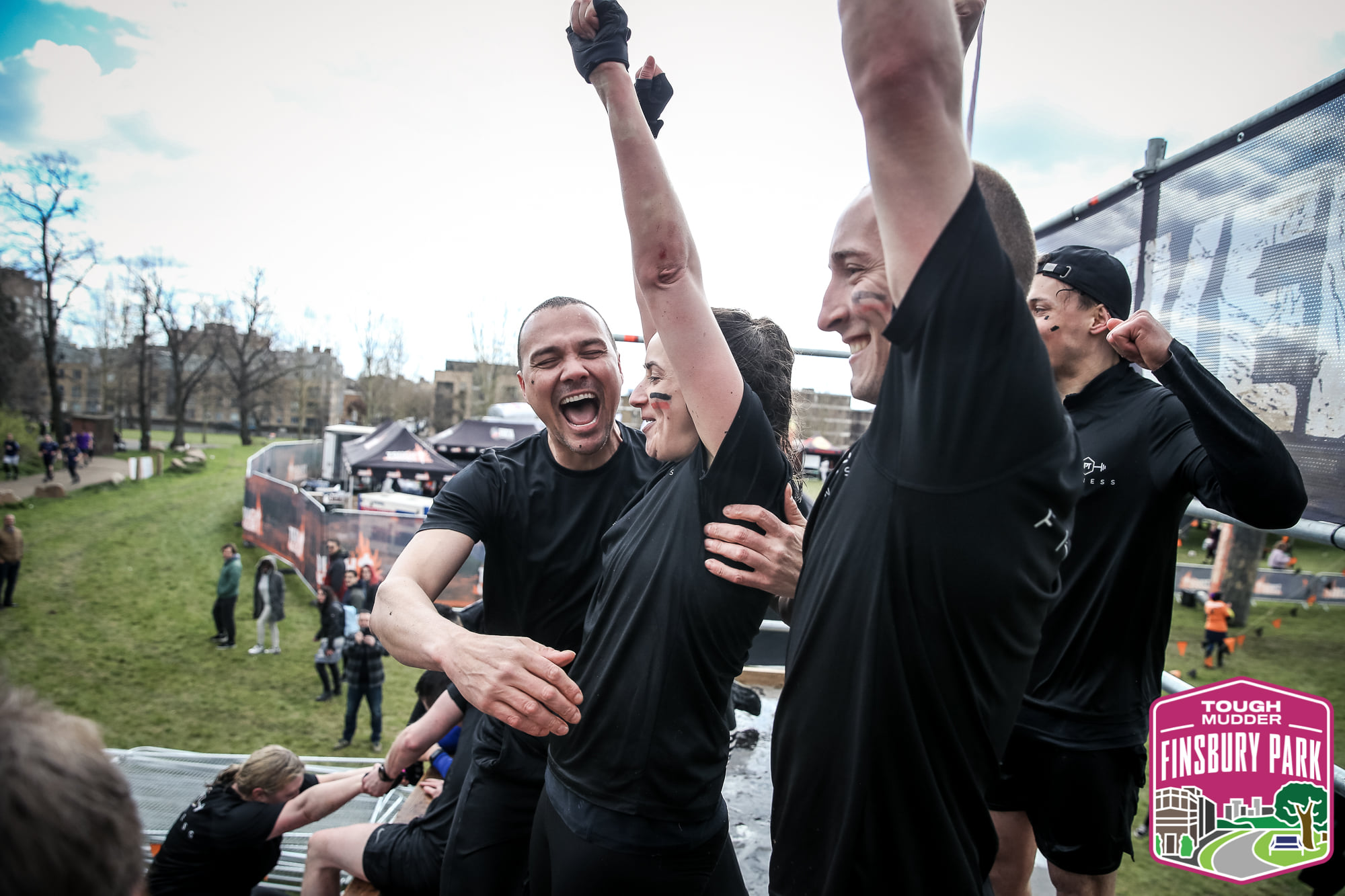 team of people cheer top of obstacle at Finsbury event